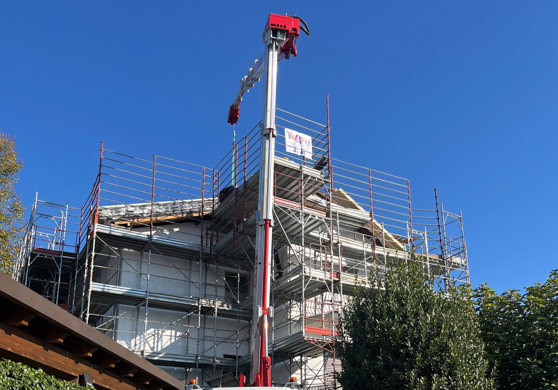 Ponteggi, gru e lavorazioni sulla copertura di un edificio